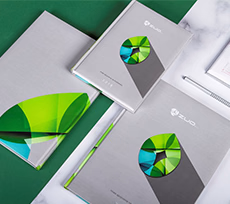 Szare kalendarze książkowe z kolorową grafiką geometryczną w odcieniach zieleni i turkusu na okładce