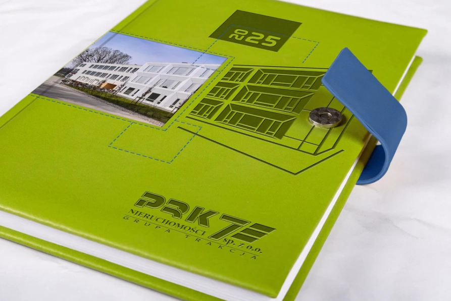 Zielony kalendarz A4 książkowy z tłoczonym motywem architektonicznym i zamknięciem na niebieską plakietkę magnetyczną