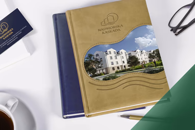 Złoty notes firmowy A5 reklamowy z tłoczonym logo i fotograficzną wstawką budynku